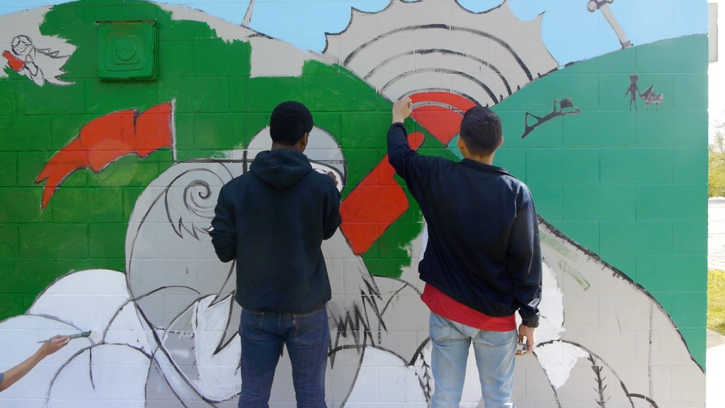 Teens paint a mural.