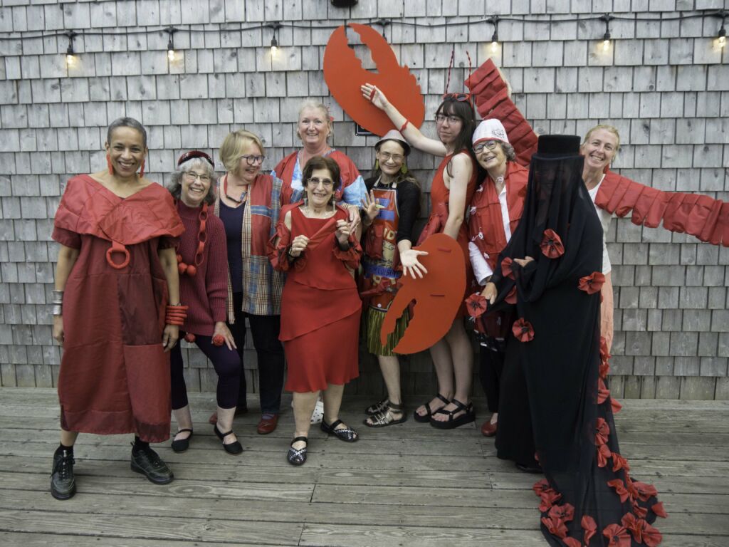 10 women dressed in red umbrella covers for a fashion show.