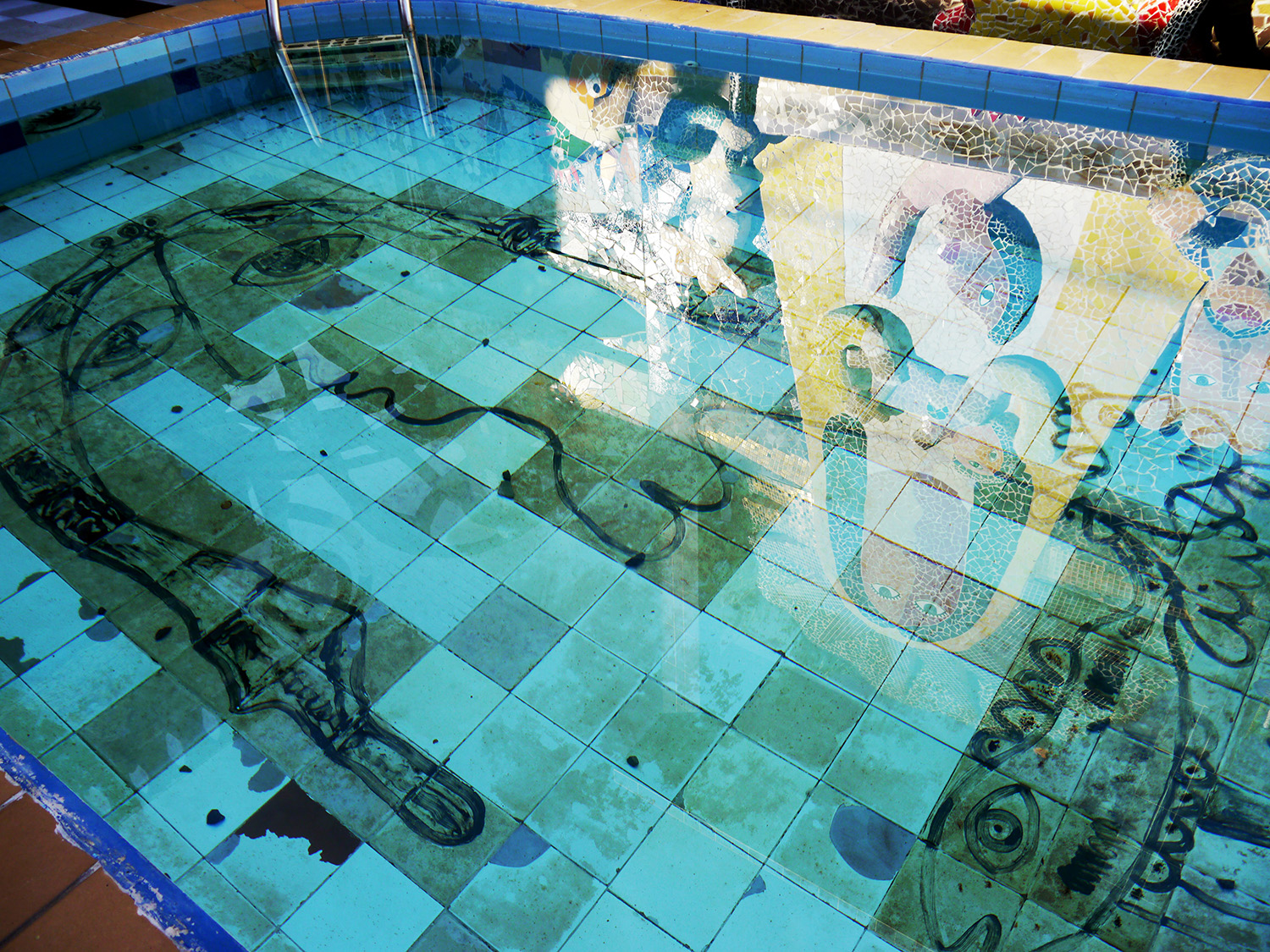 The bottom of a swimming pool features a woman's face in the style of Picasso.