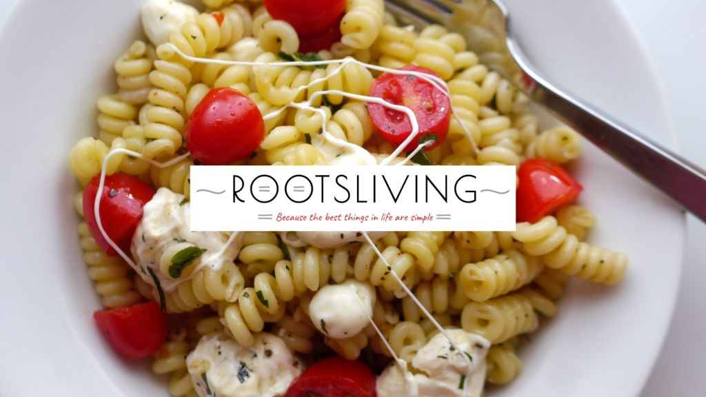 A bowl of fuscilli with tomatoes and cheese.