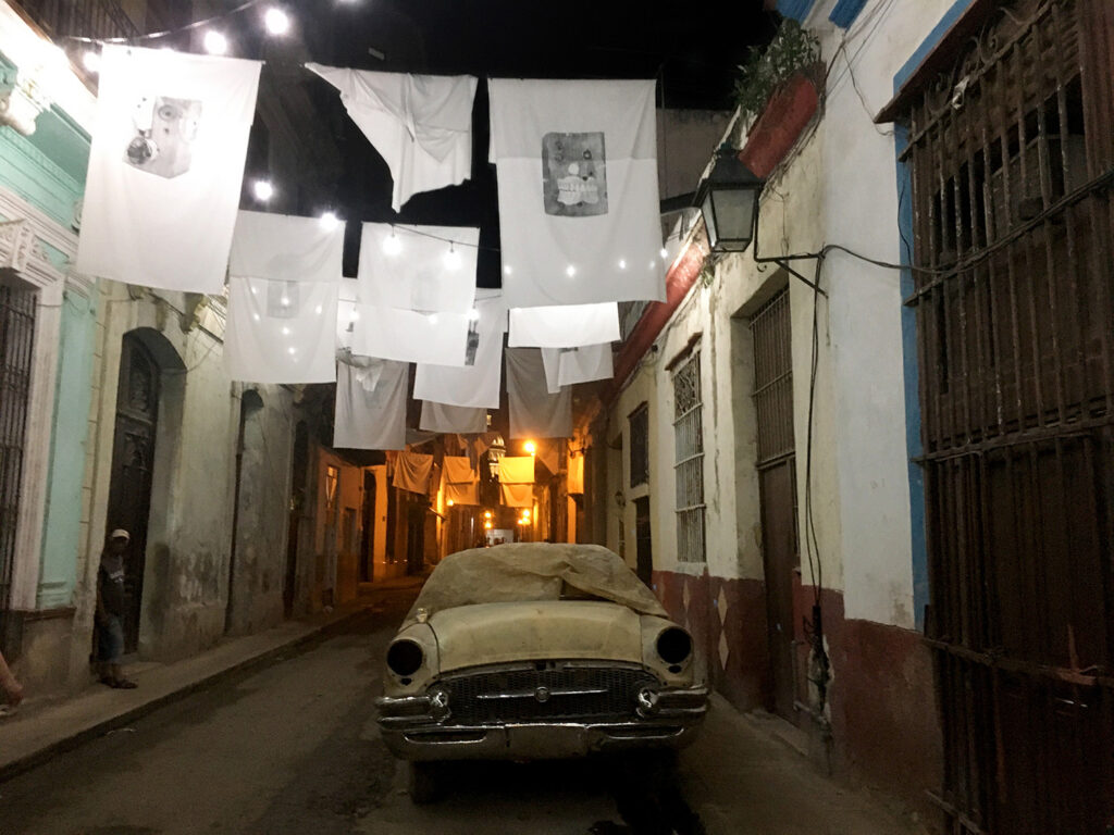 Old, rusted, 1950s car abandoned on a dark street in Old Havana.