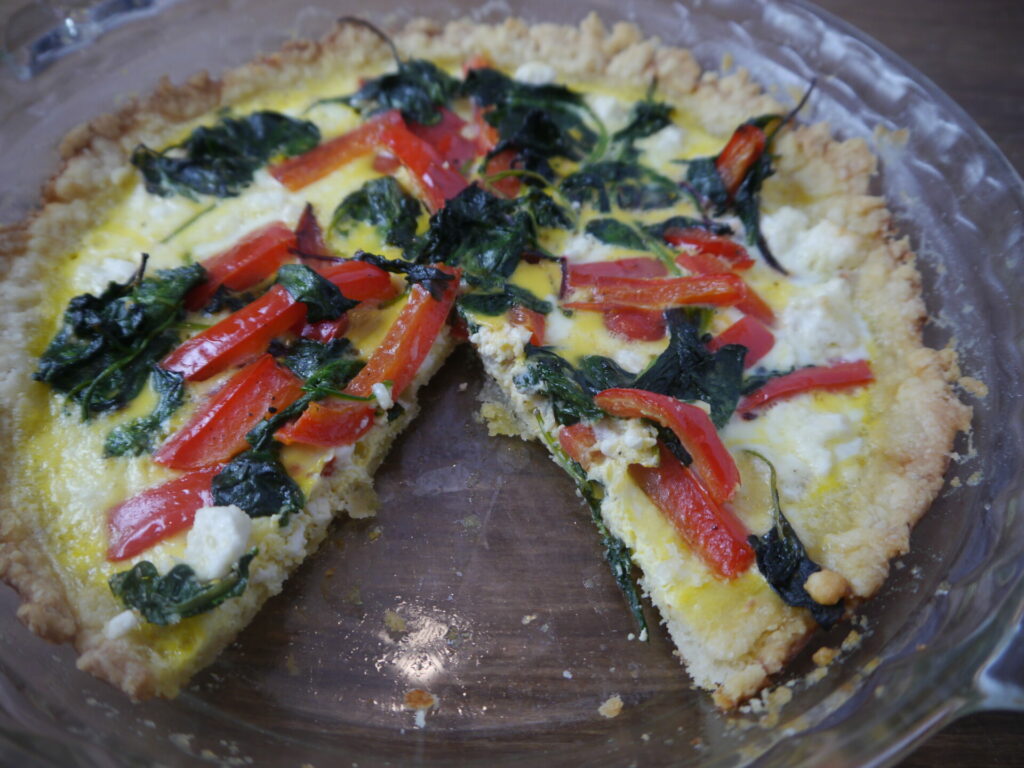 A spinache quiche with red peppers and feta cheese.