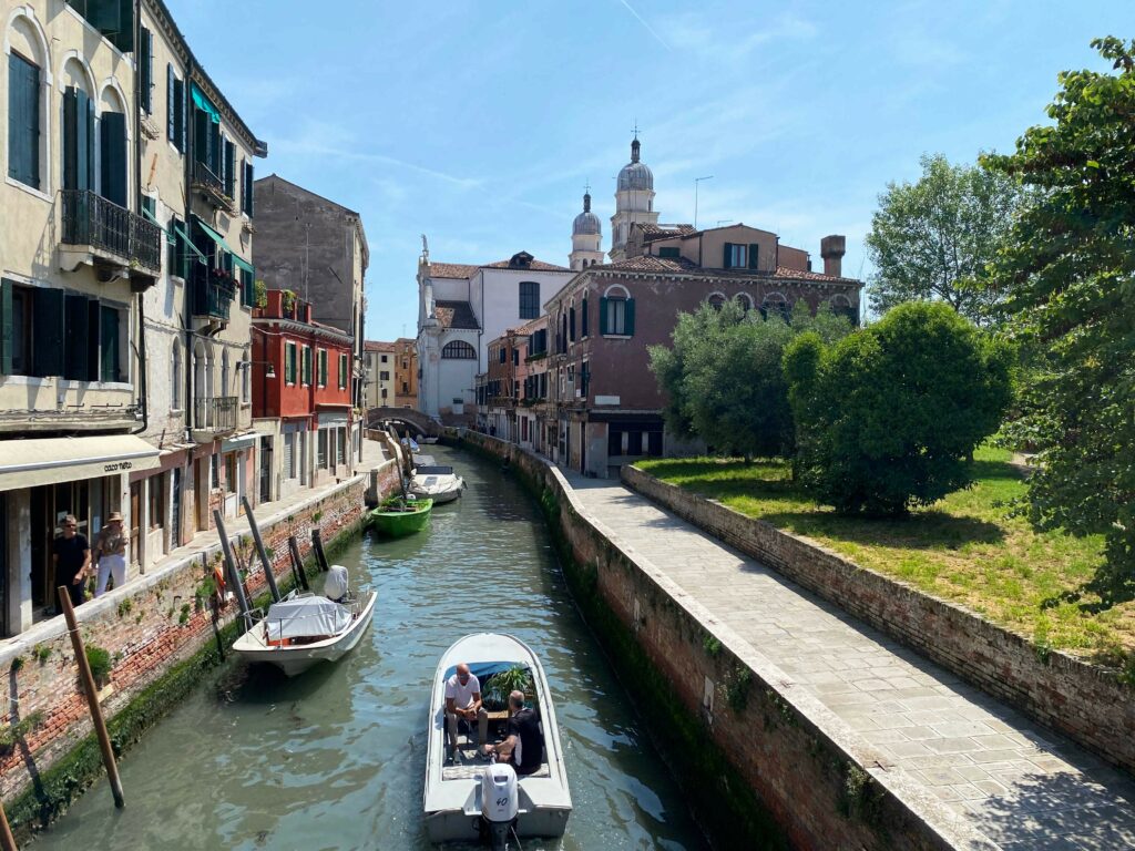 View of a boat sailing down a canal in Venice.